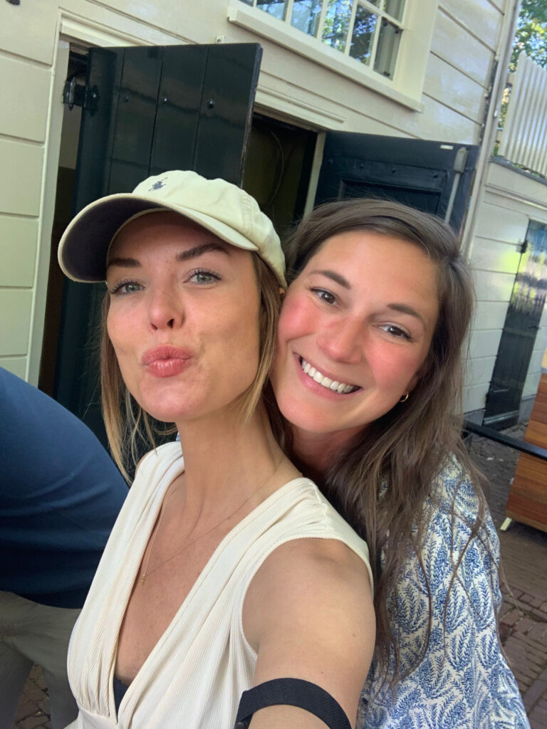 Two women smiling and taking a selfie together during a farewell gathering before starting full-time world travel.