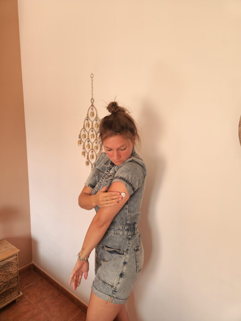 Woman with type 1 diabetes wearing a FreeStyle Libre 2+ glucose sensor on her arm while traveling