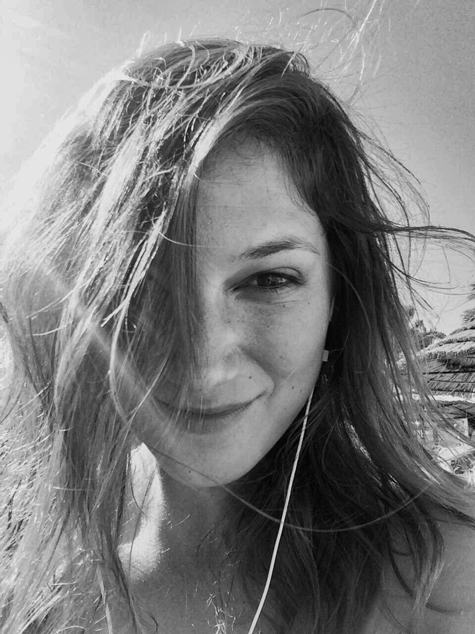 Nancy enjoying the sun on a beach, embracing the slow travel lifestyle by the sea