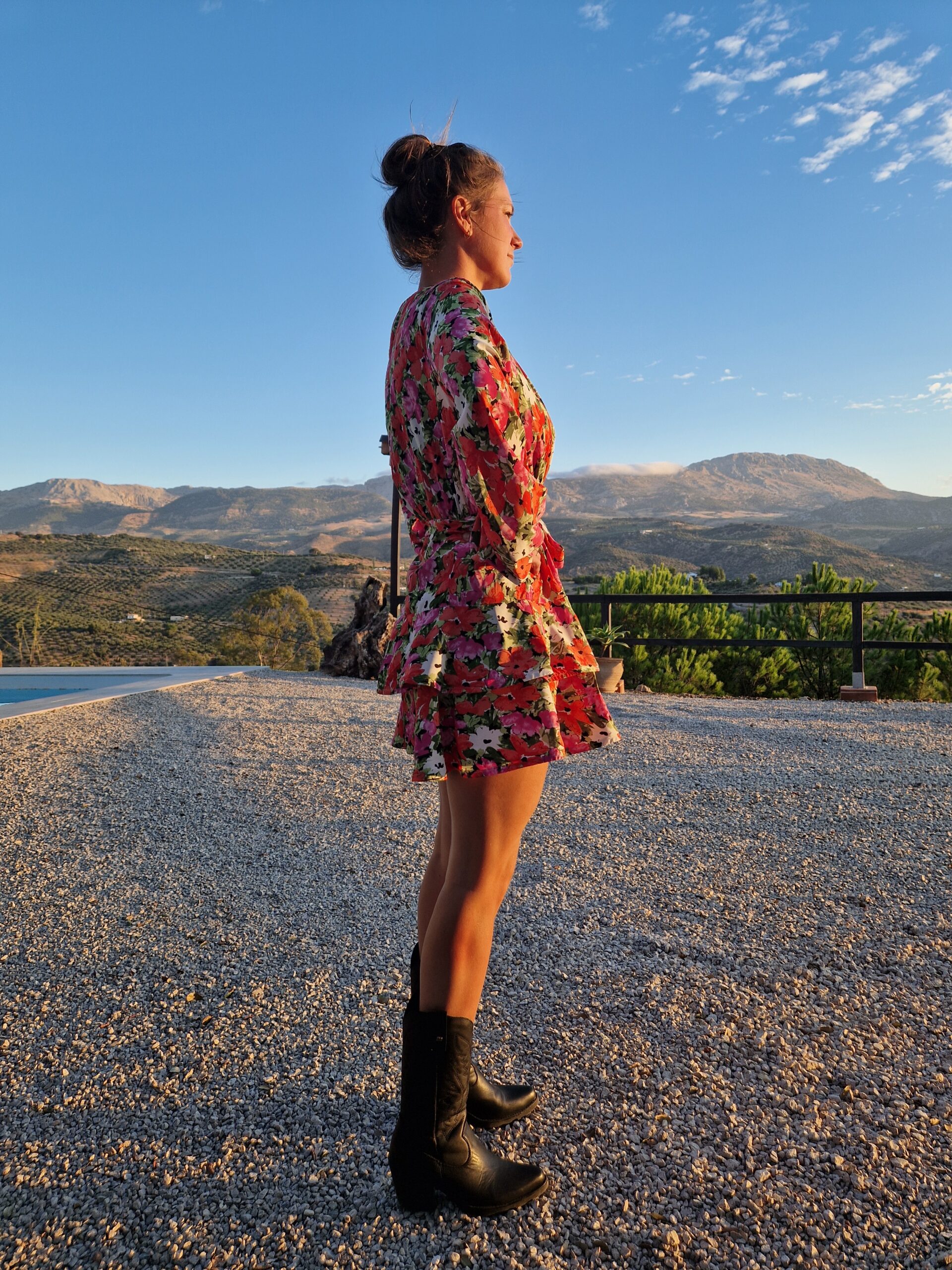 Woman with type 1 diabetes standing outside in nature during travel, reflecting while managing blood sugar on the road